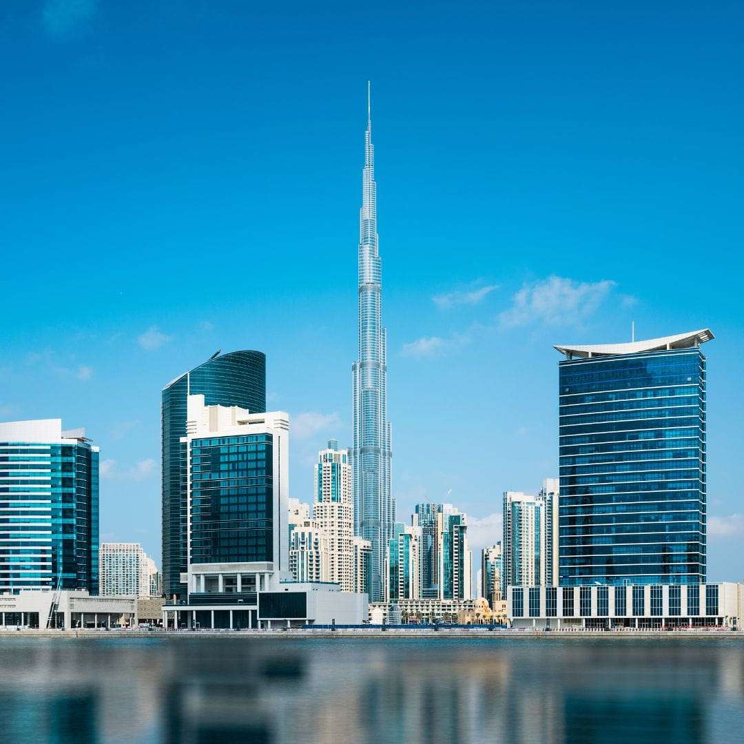 Burj Khalifa surrounded by modern skyscrapers with water reflections in Dubai, a fast-growing private jet charter destination.