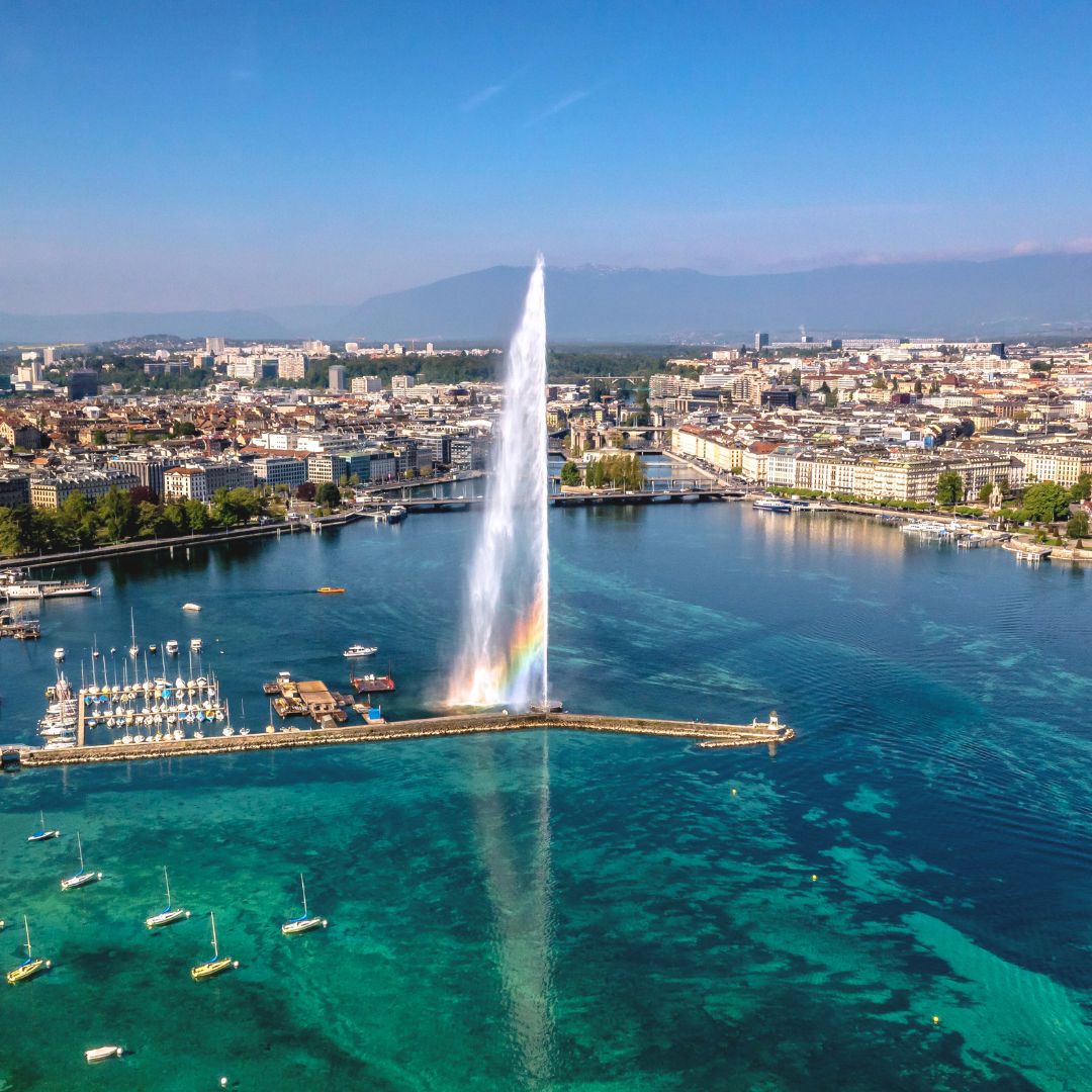 Aerial view of the Jet d'Eau fountain on Lake Geneva with city skyline, a top private jet charter destination.