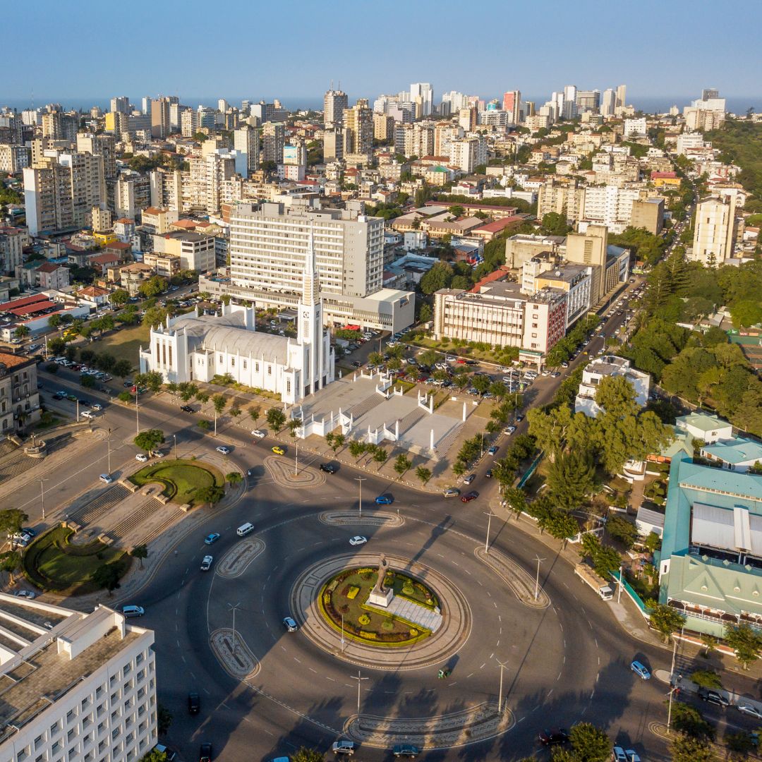 Aerial view of Maputo's Independence Square roundabout with the Cathedral of Our Lady of the Immaculate Conception and the city skyline stretching toward the Indian Ocean, Mozambique's capital for private jet charter.