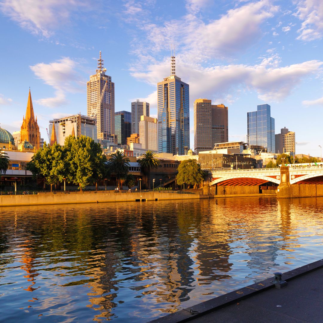 The Melbourne skyline at dusk along the Yarra River, with the city towers and gardens, one of Australia's principal business and cultural centres for private jet charter.