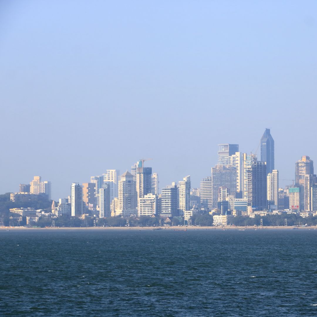 The Mumbai skyline at dusk along the Arabian Sea, with the high-rises of the financial district and Marine Drive, India's financial capital and busiest business aviation gateway for private jet charter.