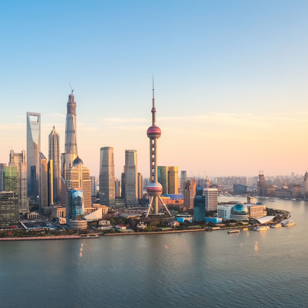 The Shanghai skyline at dusk, with the towers of the Lujiazui financial district rising across the Huangpu River from the Bund, mainland China's financial capital for private jet charter.