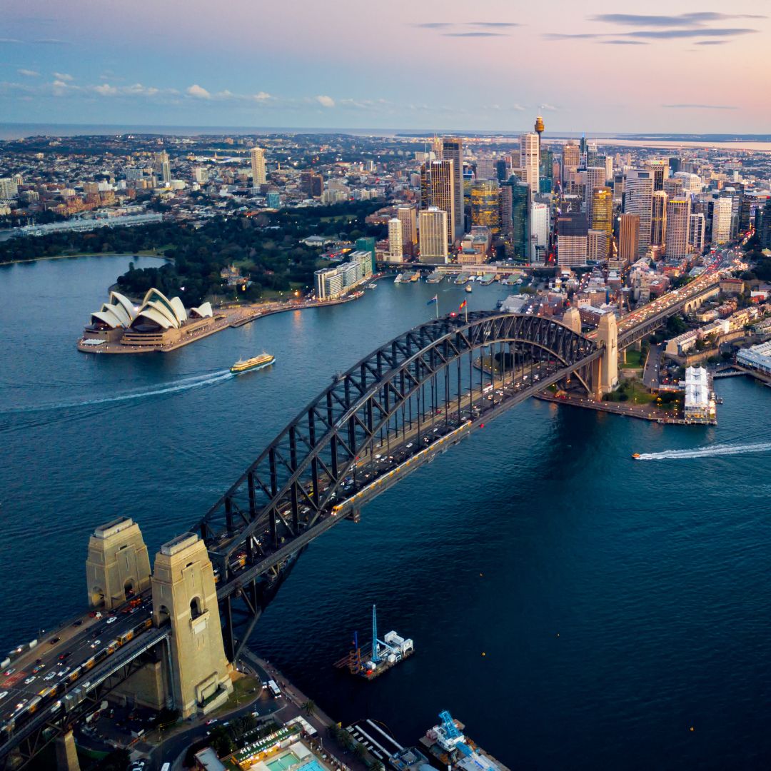 Sydney Harbour at dusk, with the Opera House and Harbour Bridge framed by the city skyline, Australia's principal business and financial centre for private jet charter.